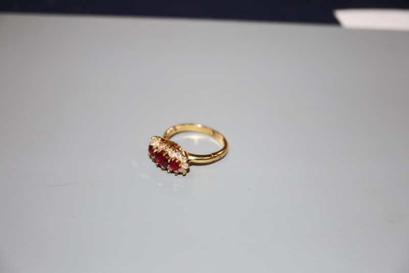 A modern yellow metal, ruby and diamond set triple cluster ring, with expanding shank, size 0-R, gross weight 5 grams.